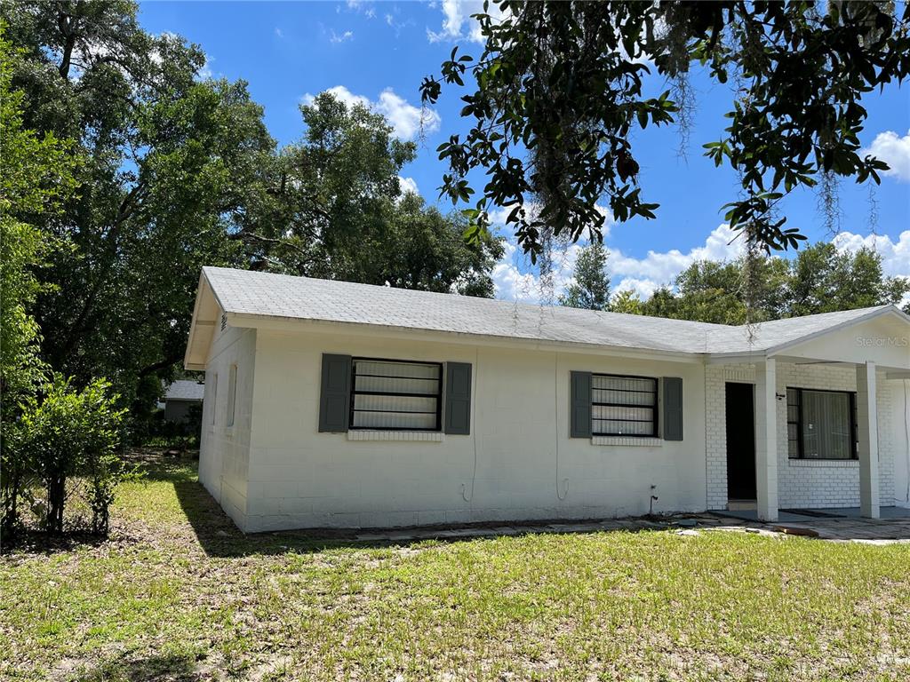 A white, single-story house with a shingled roof and dark shutters sits on a lawn — 605 PLUM LANE, ALTAMONTE SPRINGS, FL