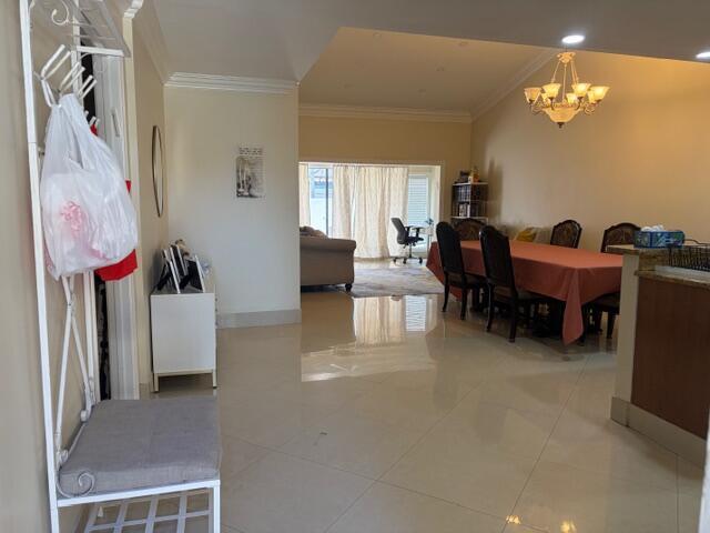 An open-concept dining and living area features tile flooring, a chandelier, and a coat rack — 7964 Little Lane, Boca Raton FL 33433, BOCA RATON, FL
