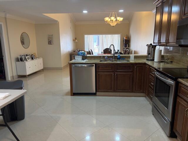 A kitchen with dark wood cabinets, stainless steel appliances, and tile flooring opens to a living area — 7964 Little Lane, Boca Raton FL 33433, BOCA RATON, FL
