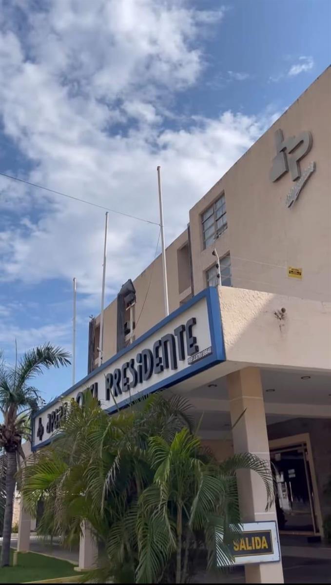 A low-angle exterior view of the Hotel Presidente building under a blue, cloudy sky — 68-50 Ave 11 #68-50 - Tierra Negra, 00000, FL