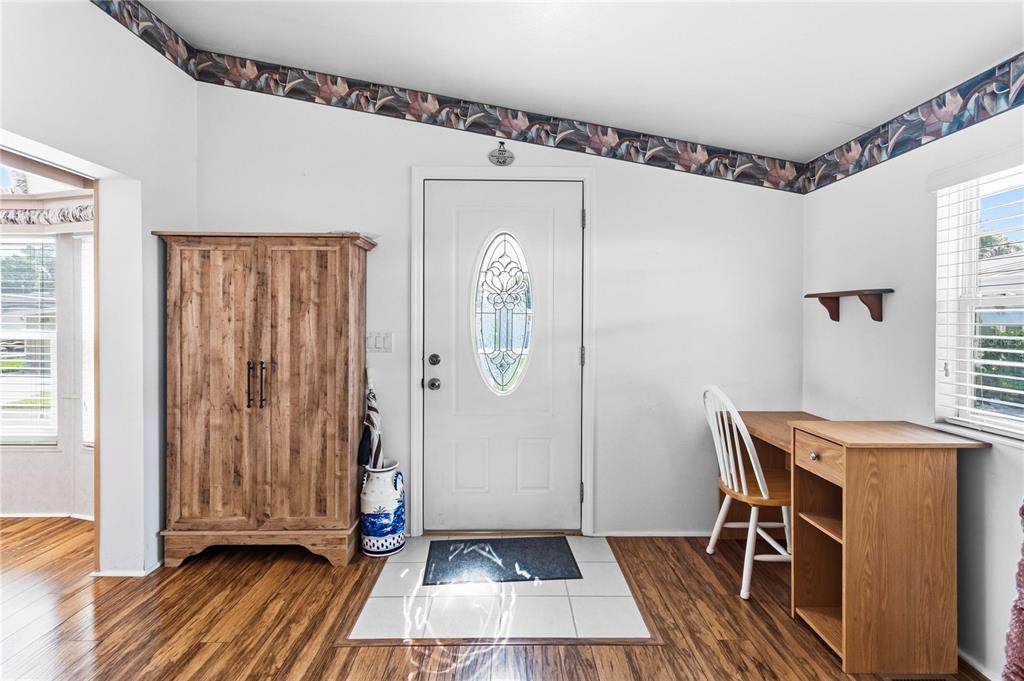 An entryway features wood-look flooring, a white front door with a glass insert, and furniture — 67 CITRUS RIDGE DRIVE, DAVENPORT, FL