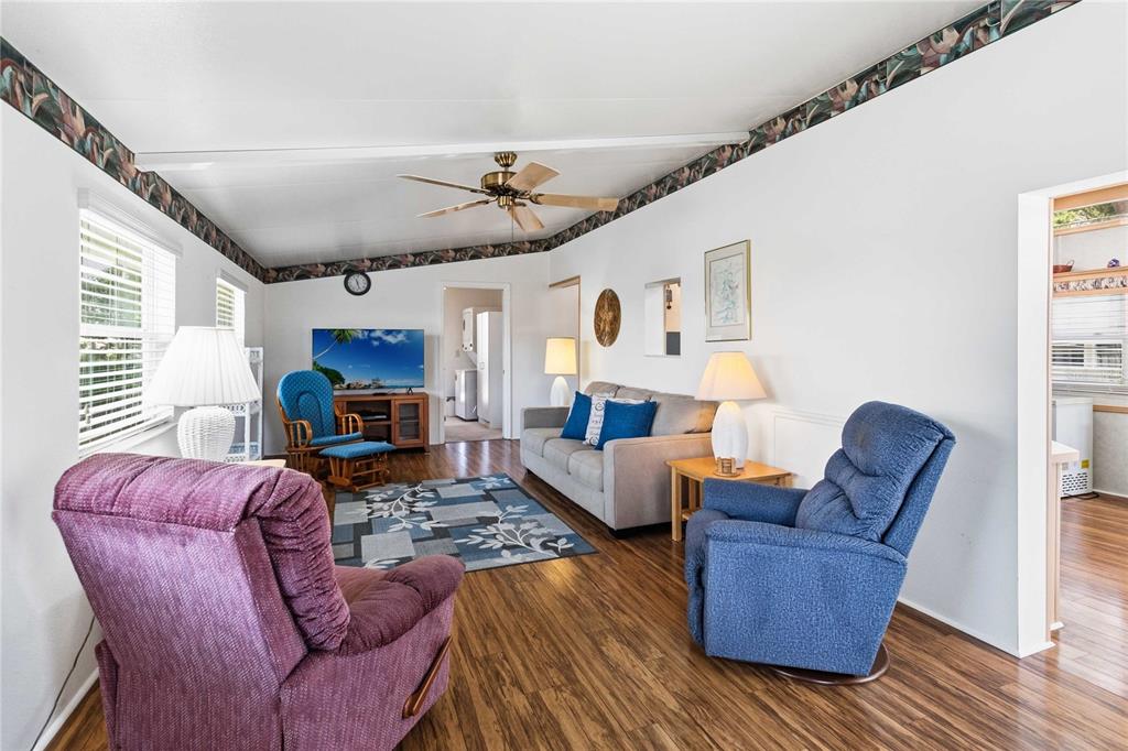 A living room features wood-look flooring, a ceiling fan, a sofa, and several armchairs — 67 CITRUS RIDGE DRIVE, DAVENPORT, FL
