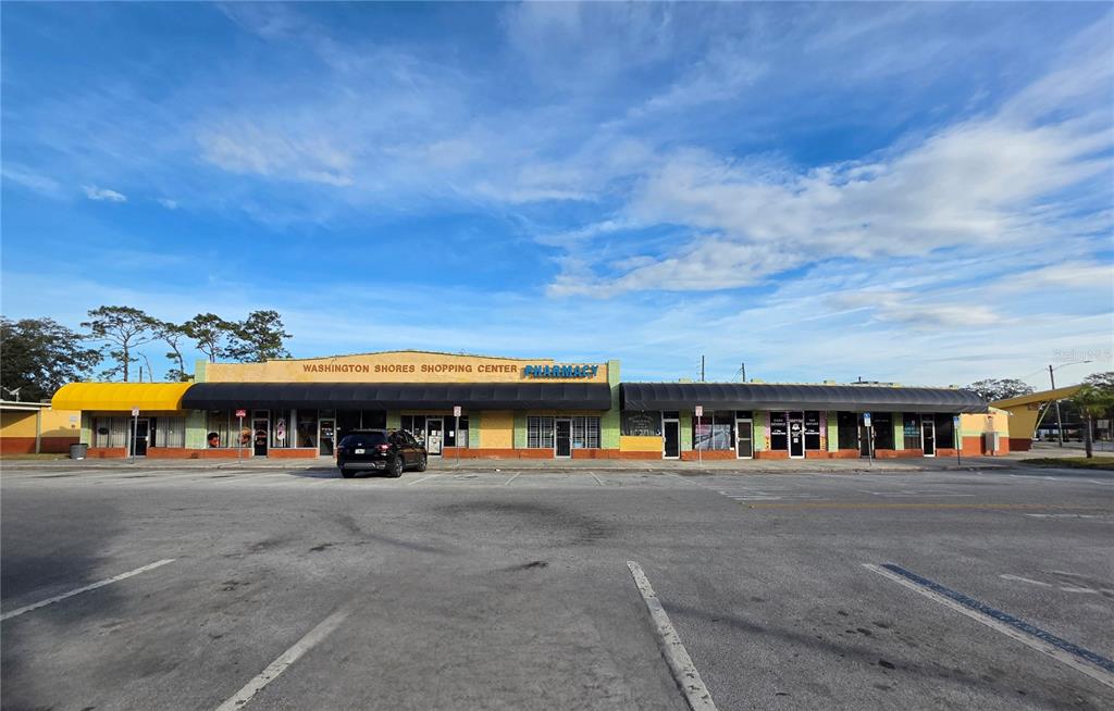 A single-story strip mall with a yellow facade and black awnings under a blue sky — 3625 COLUMBIA STREET, ORLANDO, FL