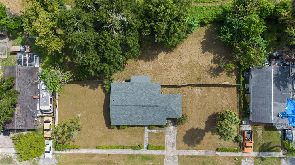 An aerial view shows a single-story house with a gray roof centered on a grassy lot — 3415 DELEUIL AVENUE, TAMPA, FL
