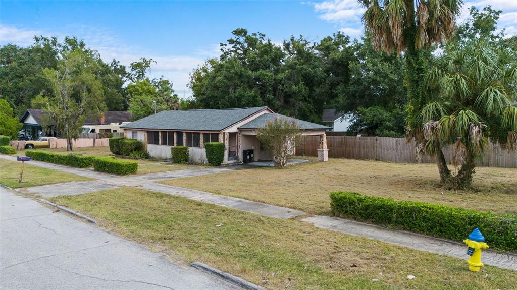 A single-story house with a carport and a large front yard sits along a street — 3415 DELEUIL AVENUE, TAMPA, FL