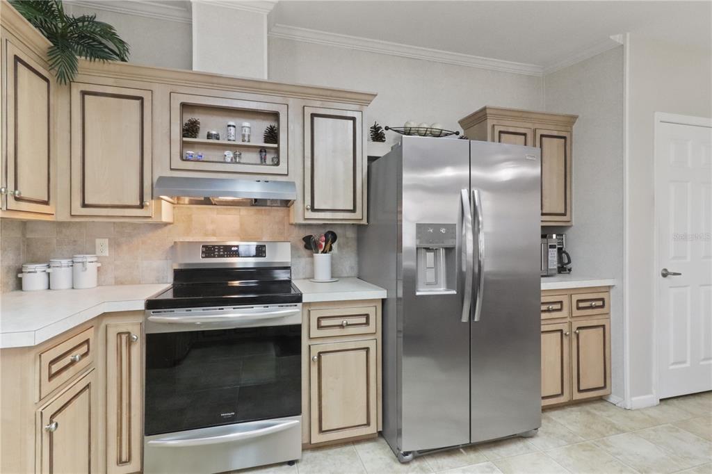 A kitchen with light wood cabinets, stainless steel appliances, and a tiled backsplash — 2100 KINGS HIGHWAY UNIT 742, PORT CHARLOTTE, FL