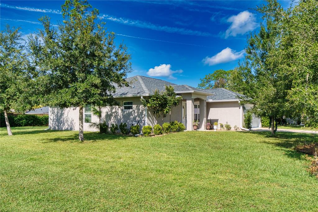 A single-story house with a light-colored exterior, a gray shingled roof, and a grassy lawn — 1 LLOSEE COURT, PALM COAST, FL