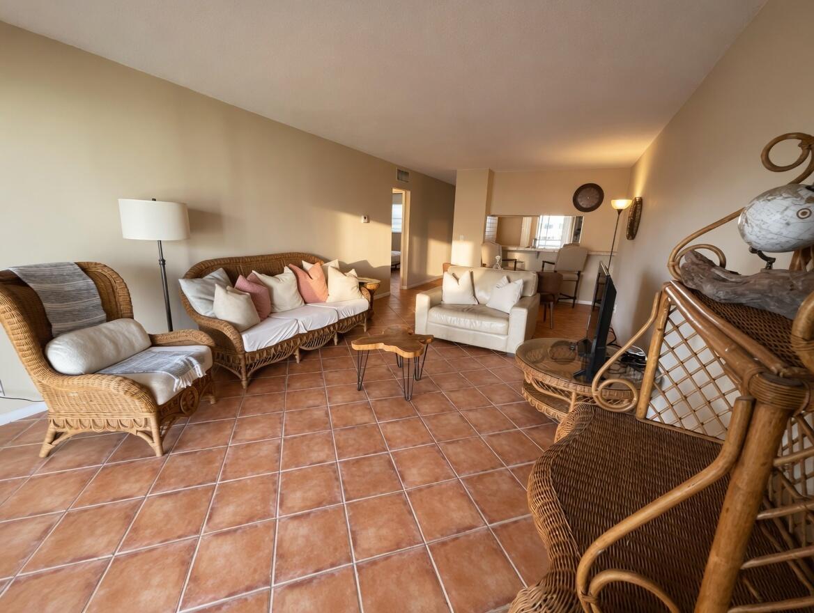 A living room features wicker furniture, a white sofa, a wood coffee table, and tile flooring — 1430 S Lakeside Drive # 22, FL 33460, FL