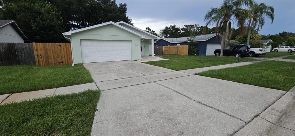 A light green single-story house with a two-car garage and a concrete driveway — 2055 DODGE STREET, CLEARWATER, FL