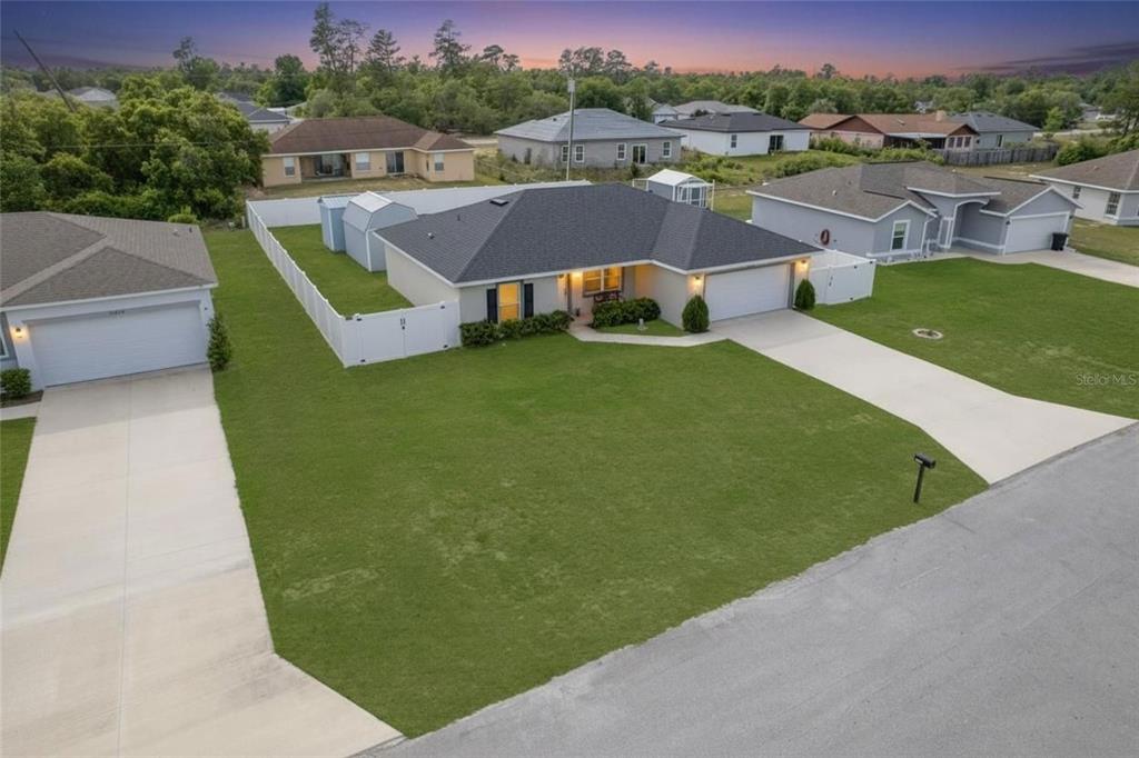 An aerial view of a single-story suburban house with a white fence and driveway — 15458 SW 23RD COURT ROAD, OCALA, FL
