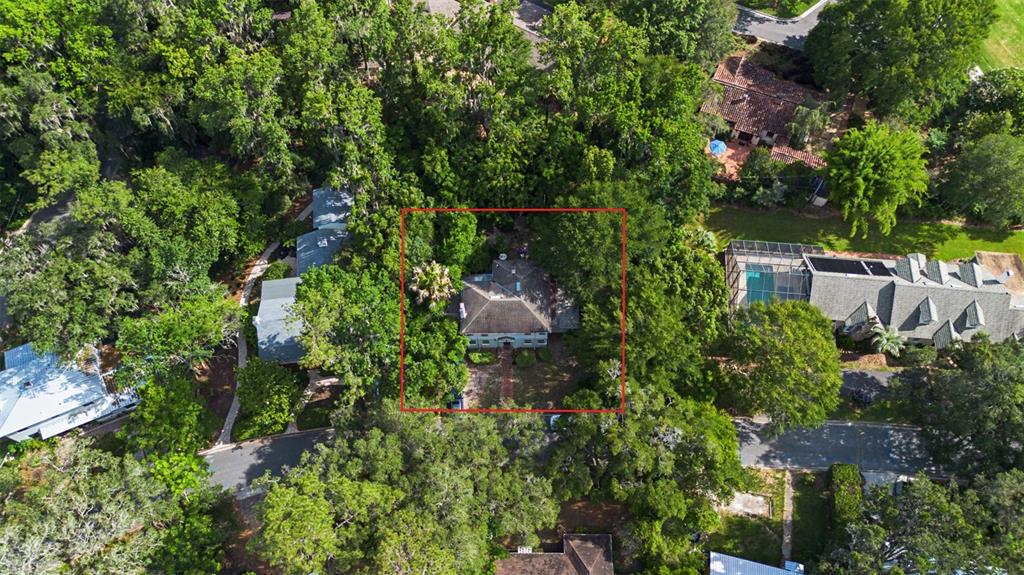 An aerial view shows a house with a hip roof surrounded by dense trees — 2721 SW 3RD PLACE, GAINESVILLE, FL
