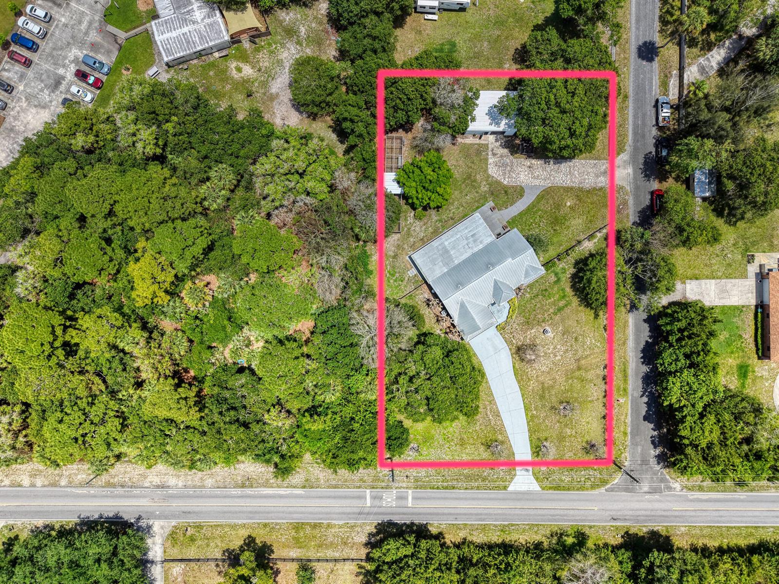 An aerial view shows a house with a metal roof and driveway on a lot — 5700 Oleander Avenue, Fort Pierce FL 34982, FORT PIERCE, FL