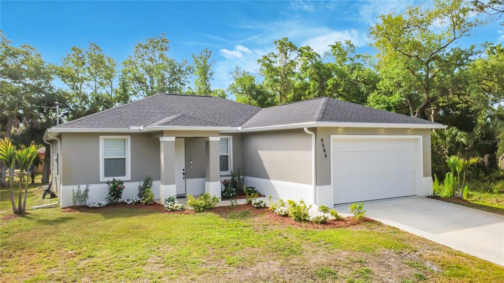 A single-story house with a gray exterior, white trim, and a two-car garage — 4586 MAURBACH TERRACE, NORTH PORT, FL