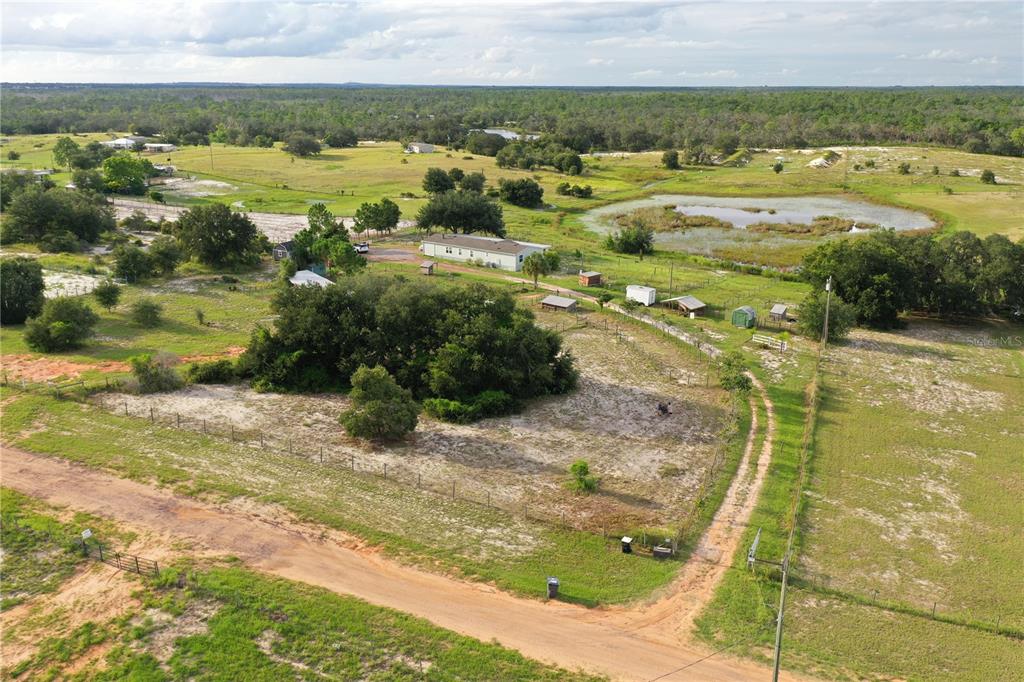 A light blue manufactured home sits on a gravel lot under a sunset sky — 713 SULTENFUSS ROAD, BABSON PARK, FL