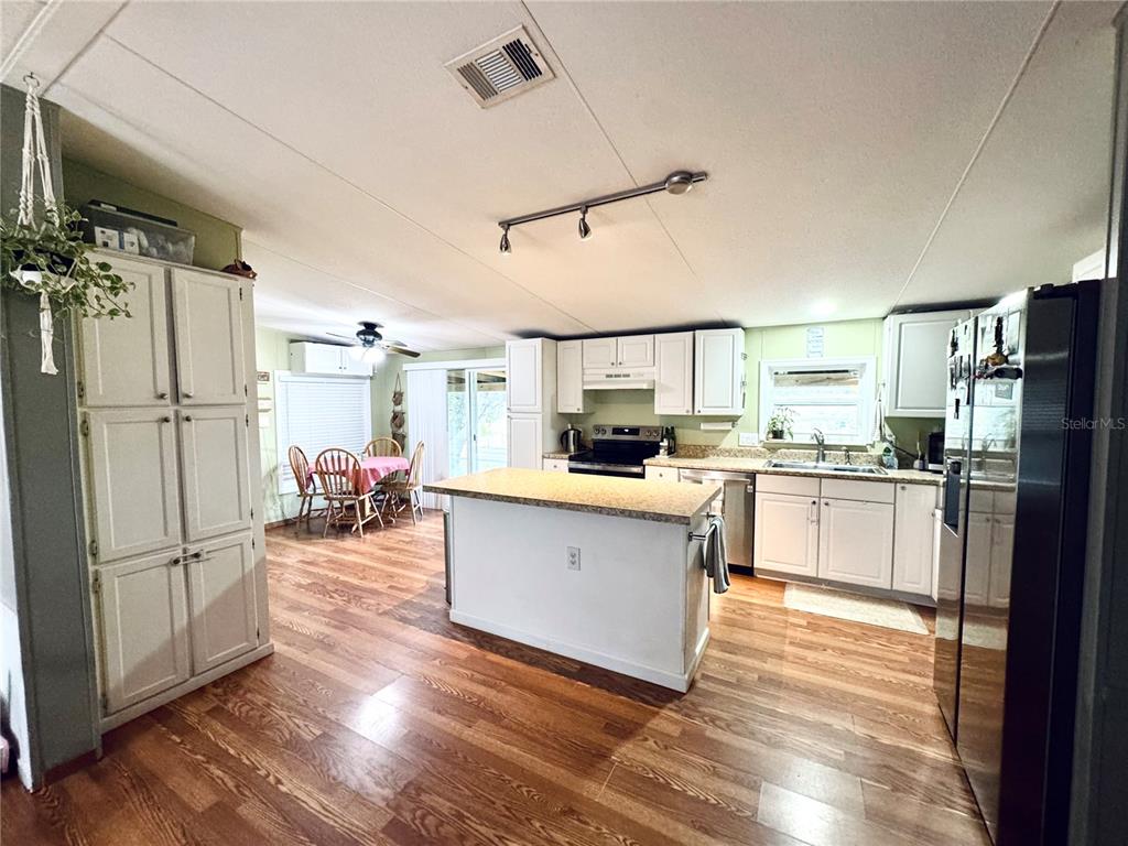 A light green mobile home exterior features a screened porch, wooden steps, and a door — 713 SULTENFUSS ROAD, BABSON PARK, FL