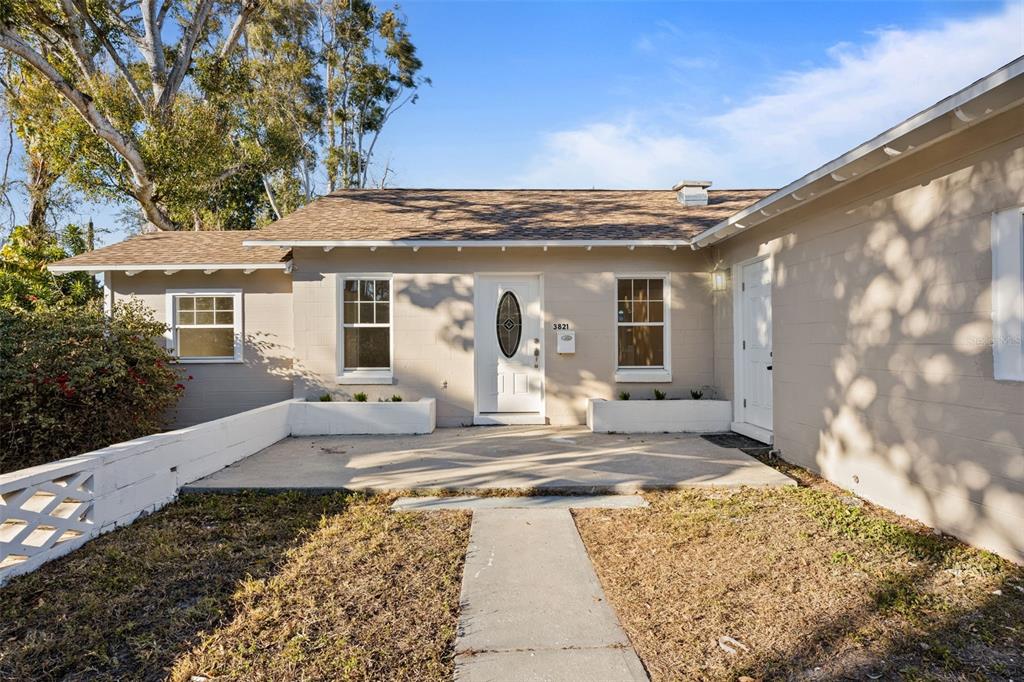 A single-story house with a concrete patio, white planters, and a central front door — 3821 6TH AVENUE N, ST PETERSBURG, FL
