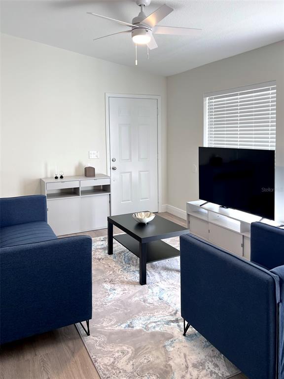 A living room features two blue sofas, a black coffee table, and a television console — 2414 CENTER AVENUE, ORLANDO, FL