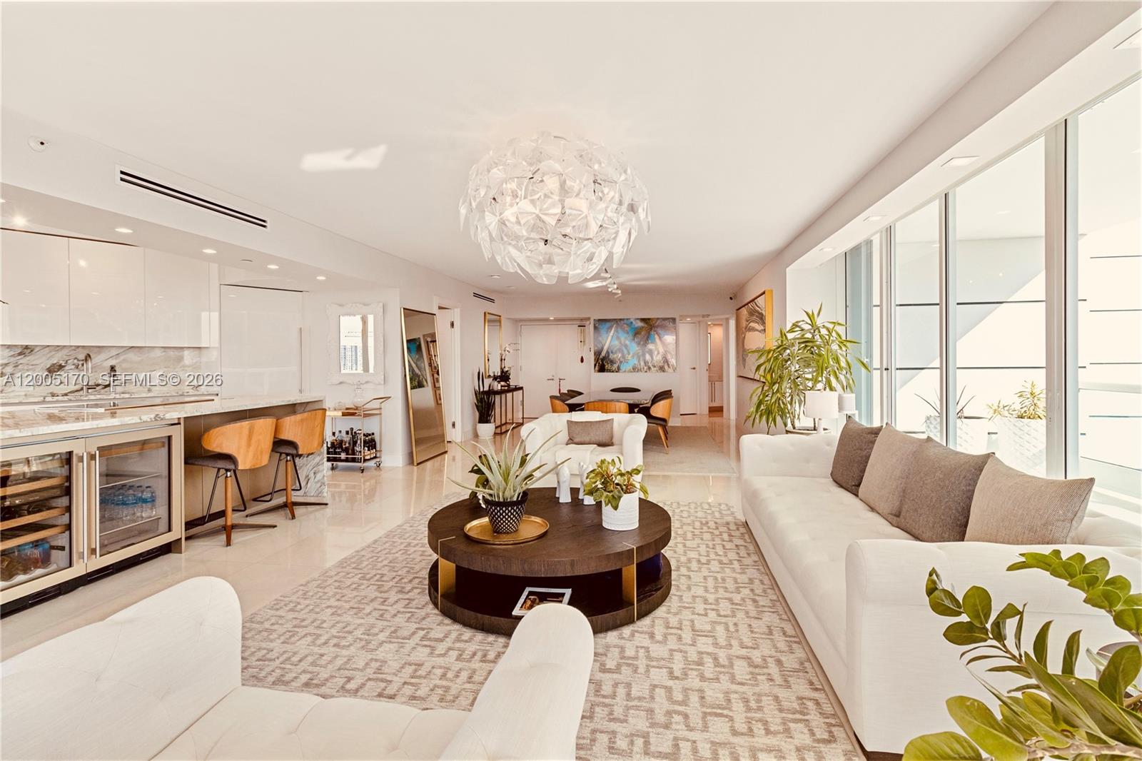 A modern open-concept living area features a kitchen, dining space, and white furniture — 2127 Brickell Ave # 1505, Miami FL 33129, MIAMI, FL