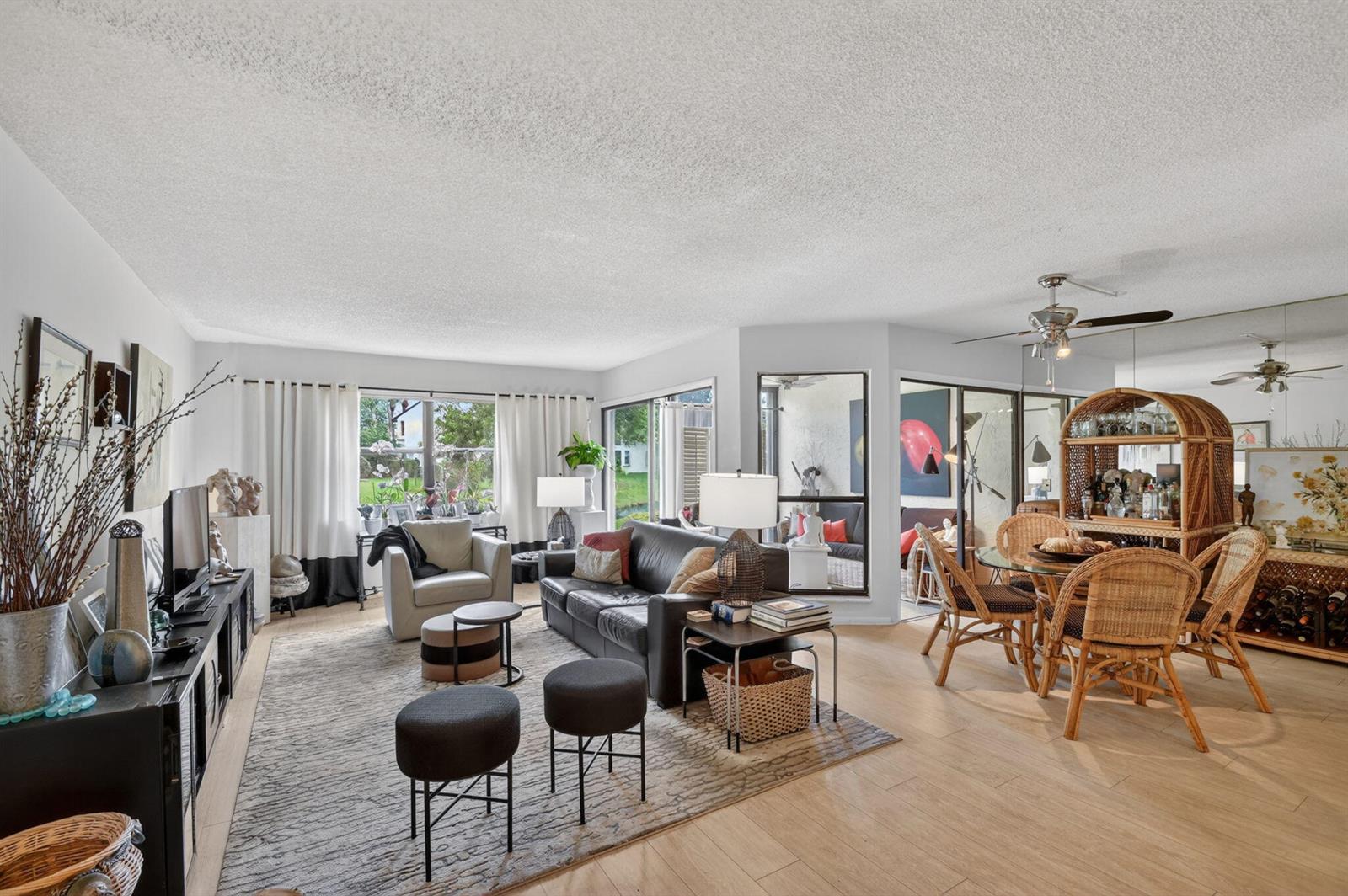 A living and dining area features a leather sofa, wicker chairs, and large glass doors — 3329 Perimeter Drive, FL 33467, FL