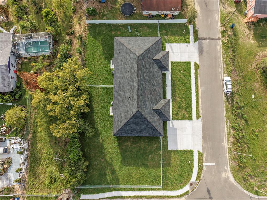 An aerial view shows a house with a dark shingled roof and a fenced yard — 304 PEARL STREET, HAINES CITY, FL