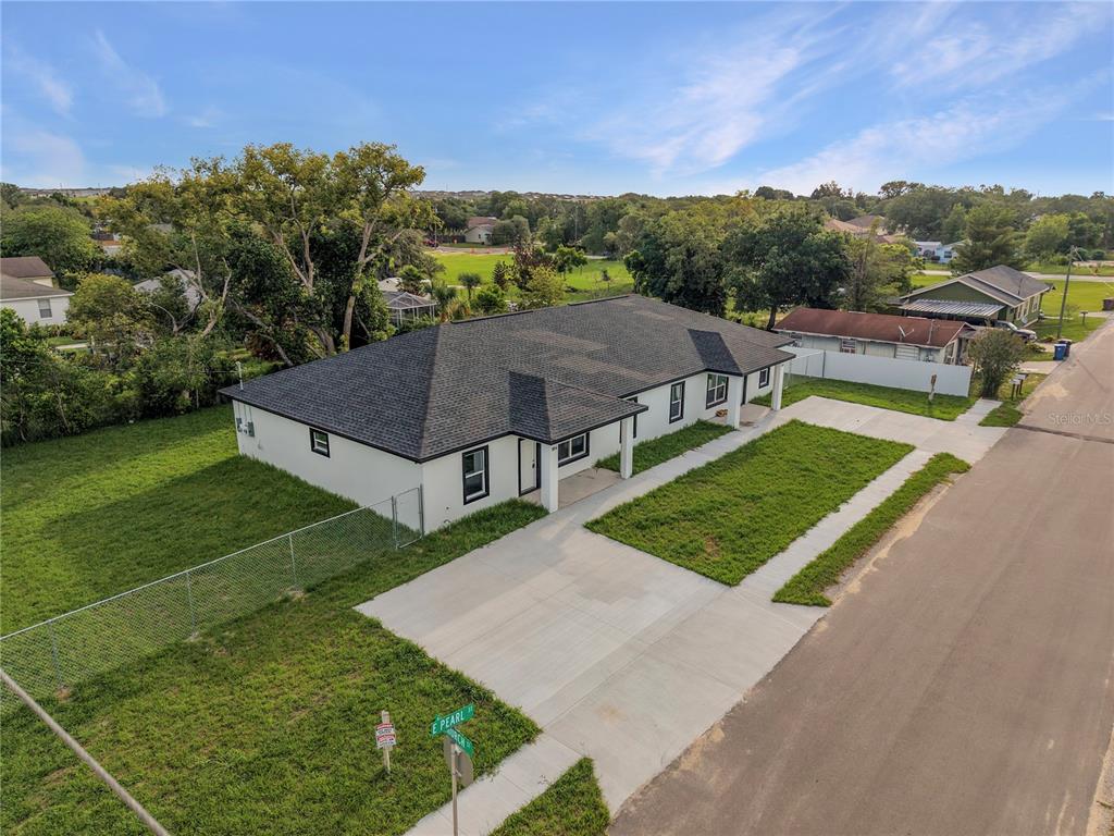 An aerial view of a single-story white house with a dark roof and concrete driveway — 304 PEARL STREET, HAINES CITY, FL