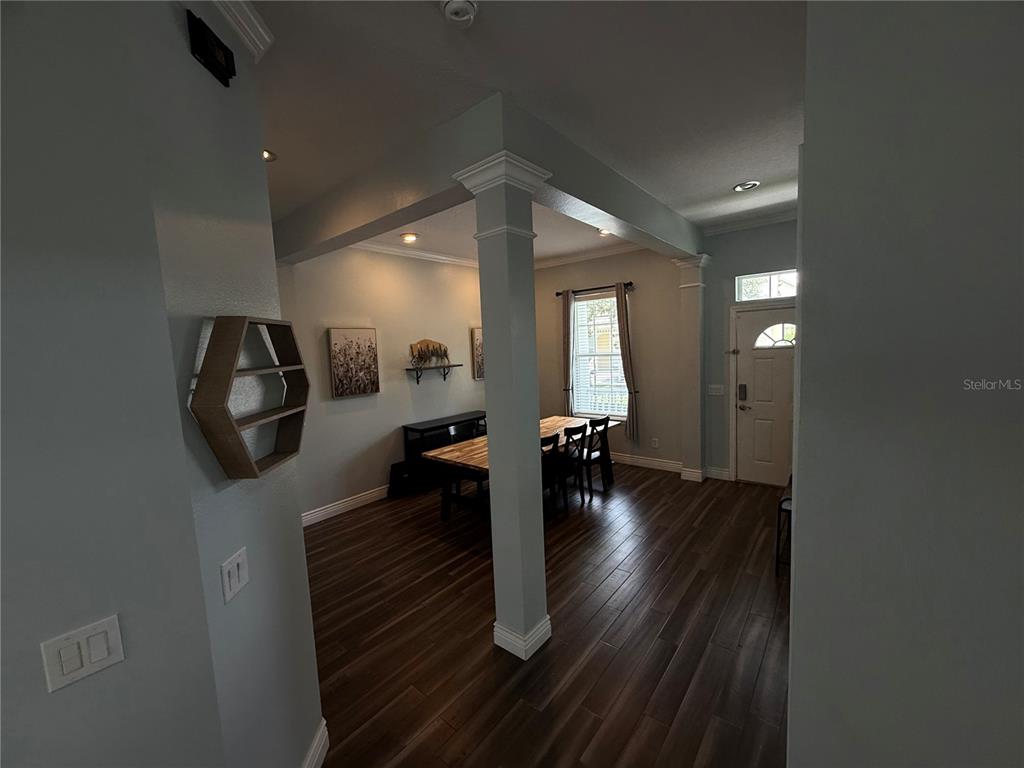 A view from a covered porch looking out toward a curved street and trees — 109 GRACE AVENUE, KISSIMMEE, FL