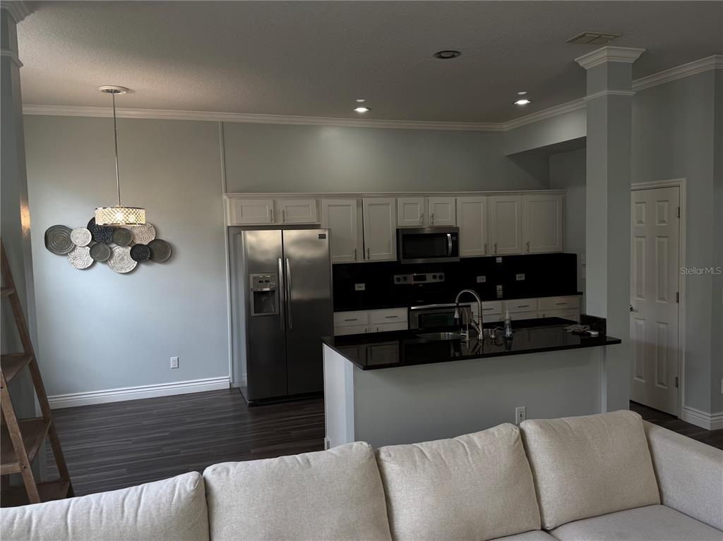 The exterior of a two-story green house features a white front door and garage — 109 GRACE AVENUE, KISSIMMEE, FL