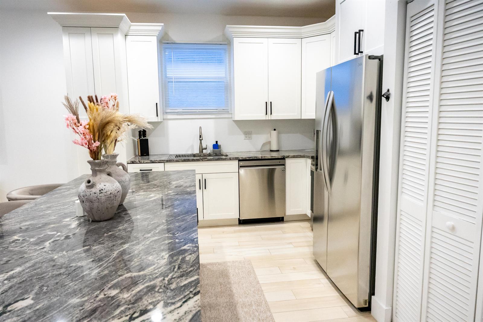 A kitchen features white cabinets, stainless steel appliances, and a dark marble-topped island — 214 N C Street, FL 33460, FL