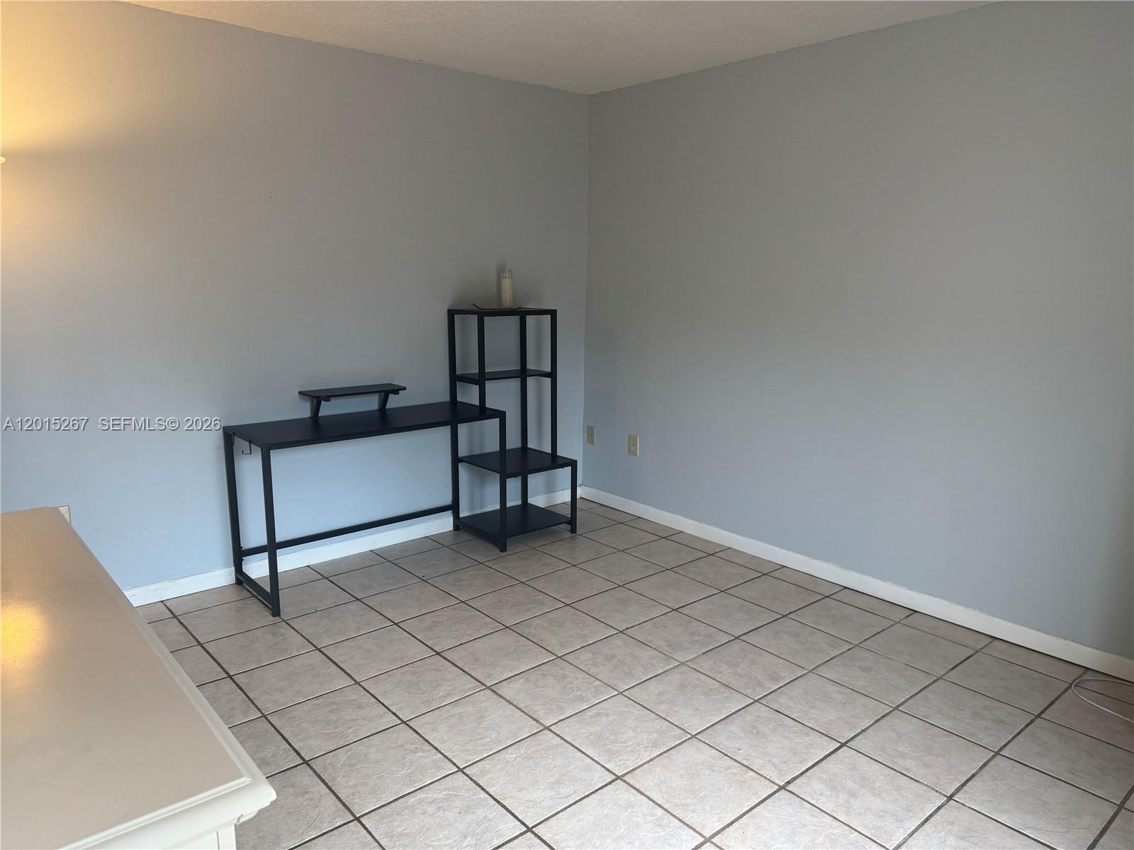 A room with light gray walls, tile flooring, and a black desk with shelving — 17016 SW 144th Ct # B, Miami FL 33177, MIAMI, FL
