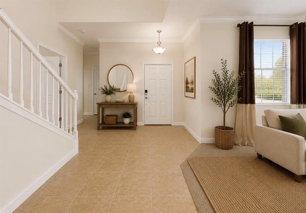 An entryway with tile flooring, a staircase, a console table, and a front door — 125 ORANGE MILL AVENUE, RUSKIN, FL