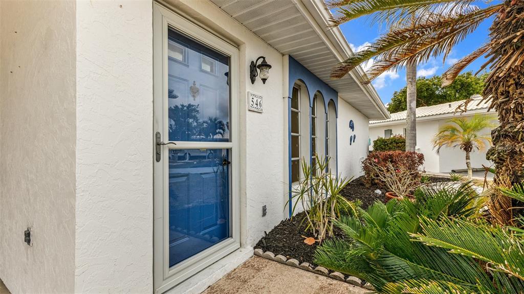 The exterior of a white house features a blue storm door and arched windows — 546 CIRCLEWOOD DRIVE UNIT P3-4, VENICE, FL