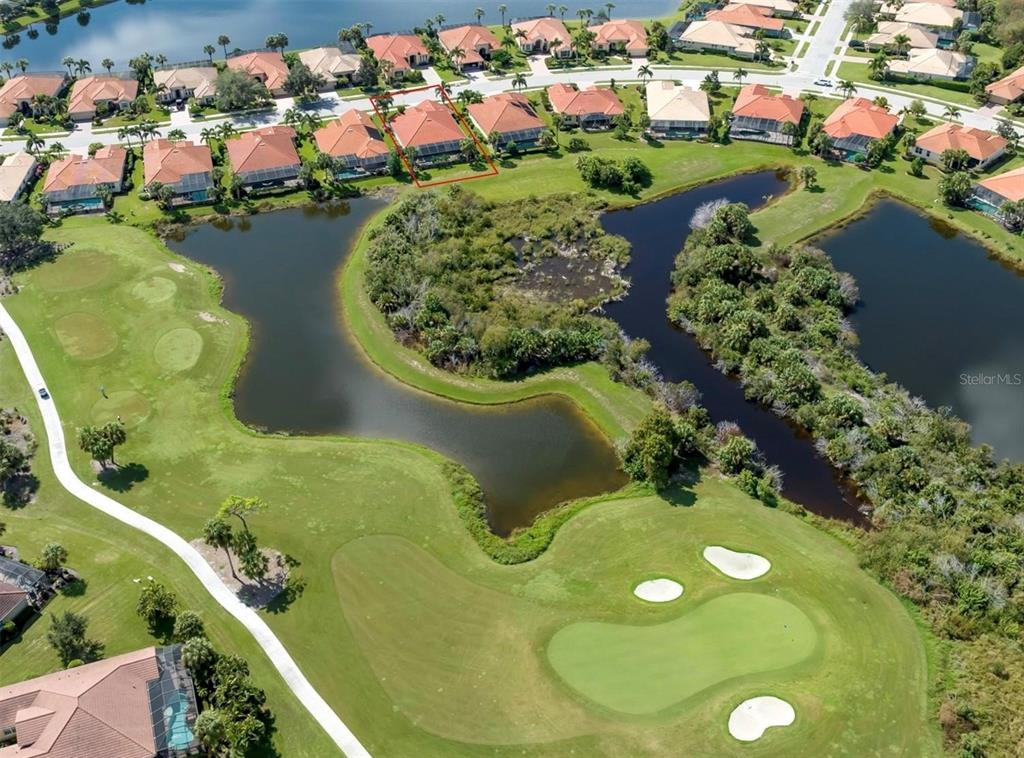 An aerial view shows a residential house with a pool cage overlooking a golf course — 194 MONTELLUNA DRIVE, NORTH VENICE, FL