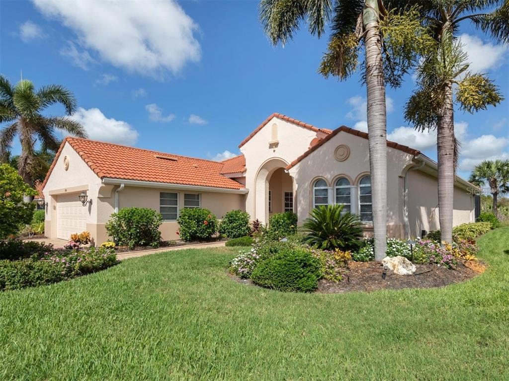 A single-story stucco house with a red tile roof and palm trees in the yard — 194 MONTELLUNA DRIVE, NORTH VENICE, FL