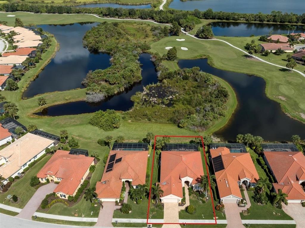 An aerial view shows a house outlined in red, situated on a golf course lot — 194 MONTELLUNA DRIVE, NORTH VENICE, FL