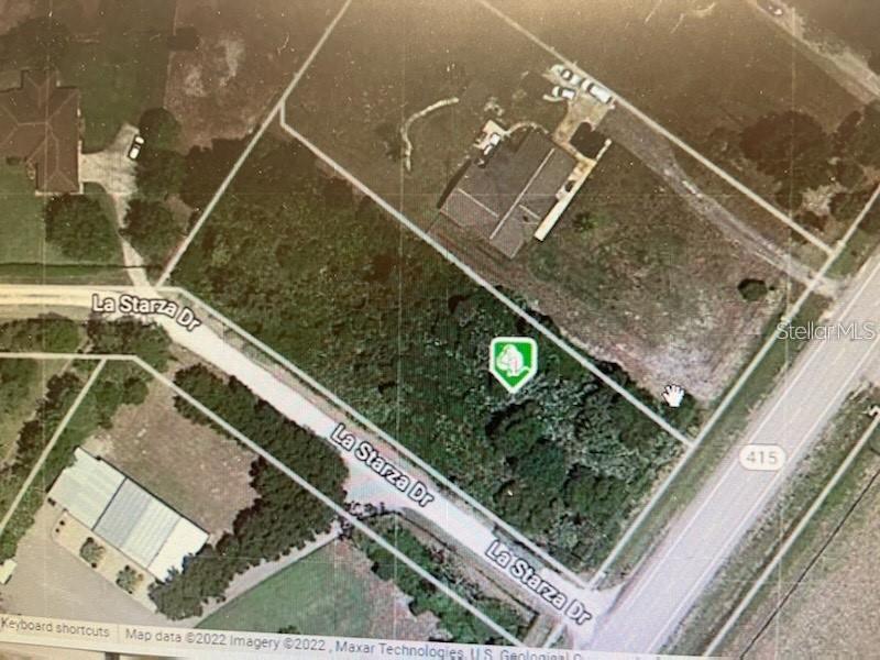 This is an aerial map view showing a vacant, wooded lot bordered by a road — SR-415, NEW SMYRNA BEACH, FL