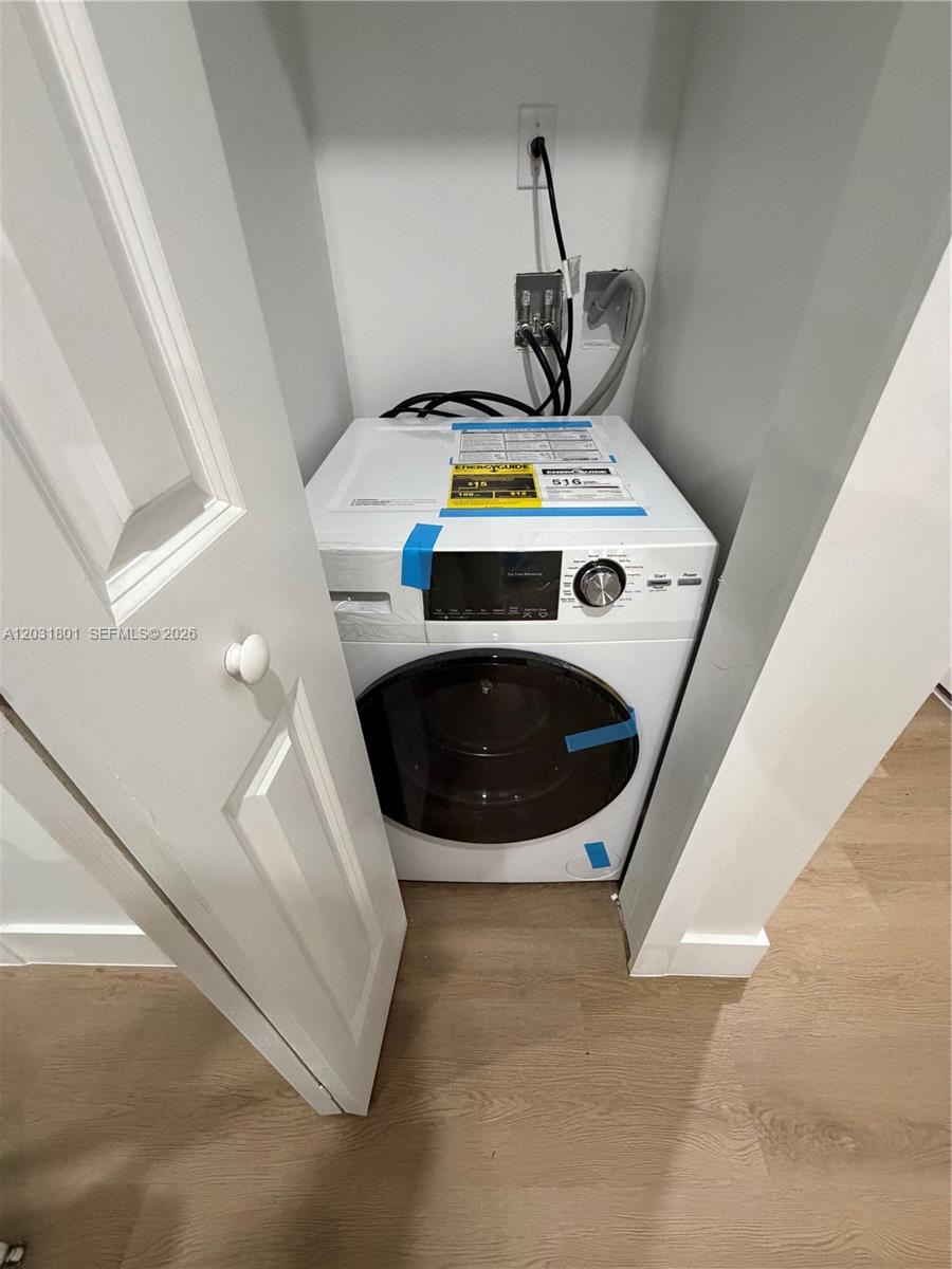 A new white front-loading washing machine is installed in a small laundry closet — 1619 Jefferson Ave # 210, Miami Beach FL 33139, MIAMI BEACH, FL