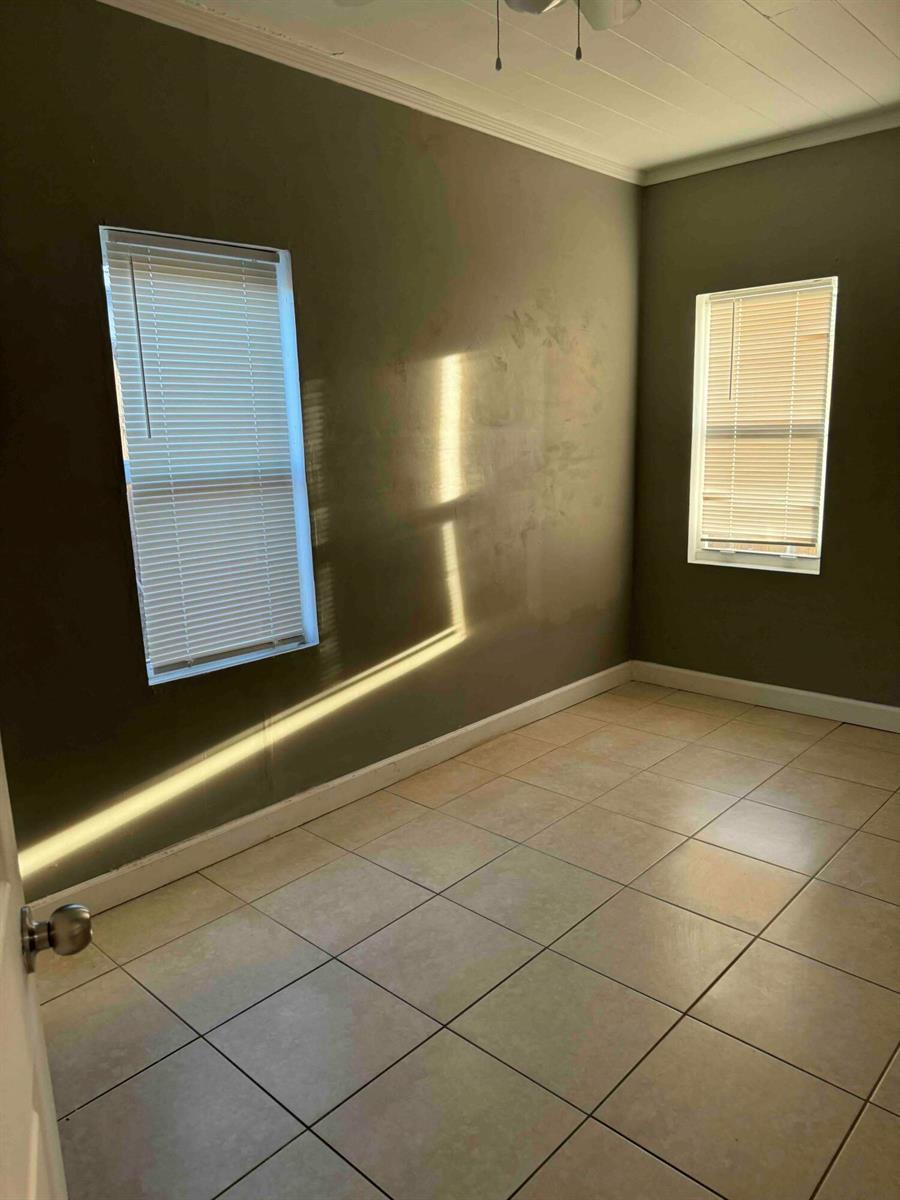 An empty room features olive-colored walls, light-colored tile flooring, and two windows with white blinds — 717 S B Street # 715, FL 33460, FL