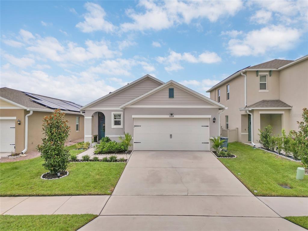A single-story suburban house with a gray exterior, a two-car garage, and a concrete driveway — 3664 SUNGROVE CIRCLE, SANFORD, FL