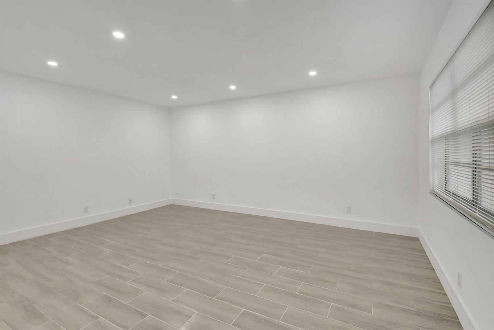 An empty room with white walls, recessed lighting, and light-colored wood-look tile flooring — 126 Burgundy # C, Delray Beach FL 33484, DELRAY BEACH, FL