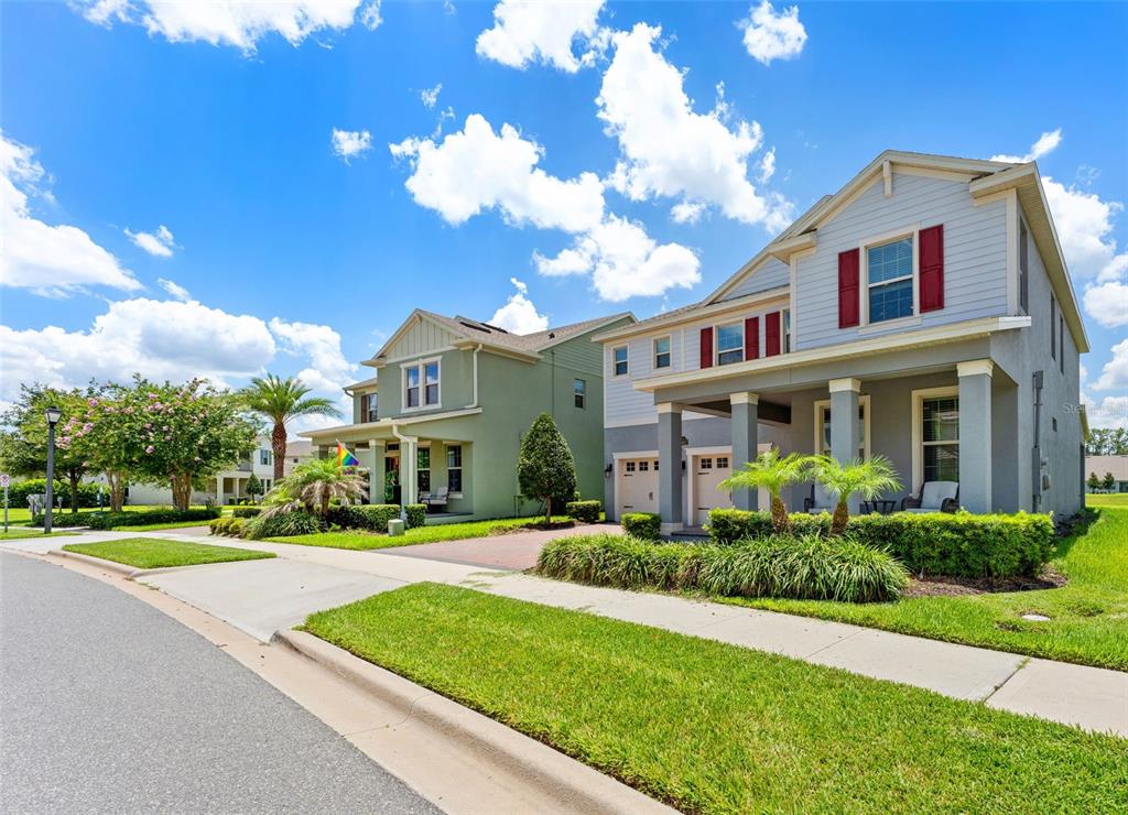 Two suburban houses with light-colored siding and front porches sit along a paved street — 8807 SONOMA COAST DRIVE, WINTER GARDEN, FL