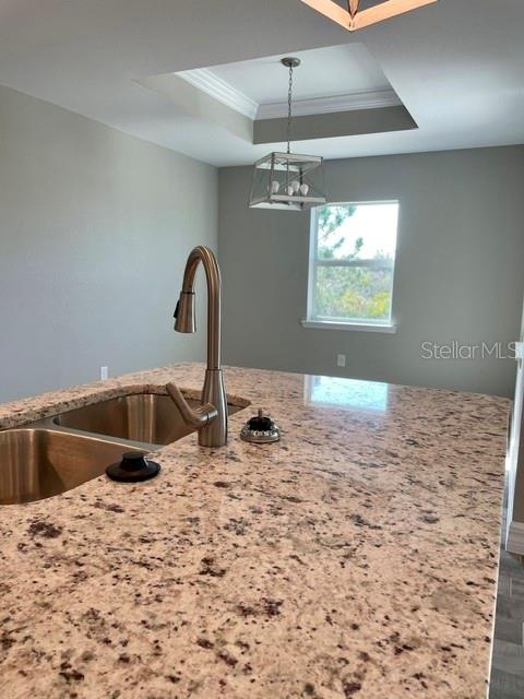 A kitchen island with a stainless steel sink and granite countertop sits before a window — 203 BAYTREE DRIVE, ROTONDA WEST, FL