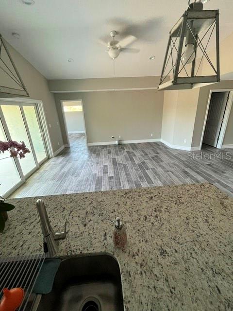 A view from a kitchen island overlooking an open living area with wood-look tile flooring — 203 BAYTREE DRIVE, ROTONDA WEST, FL