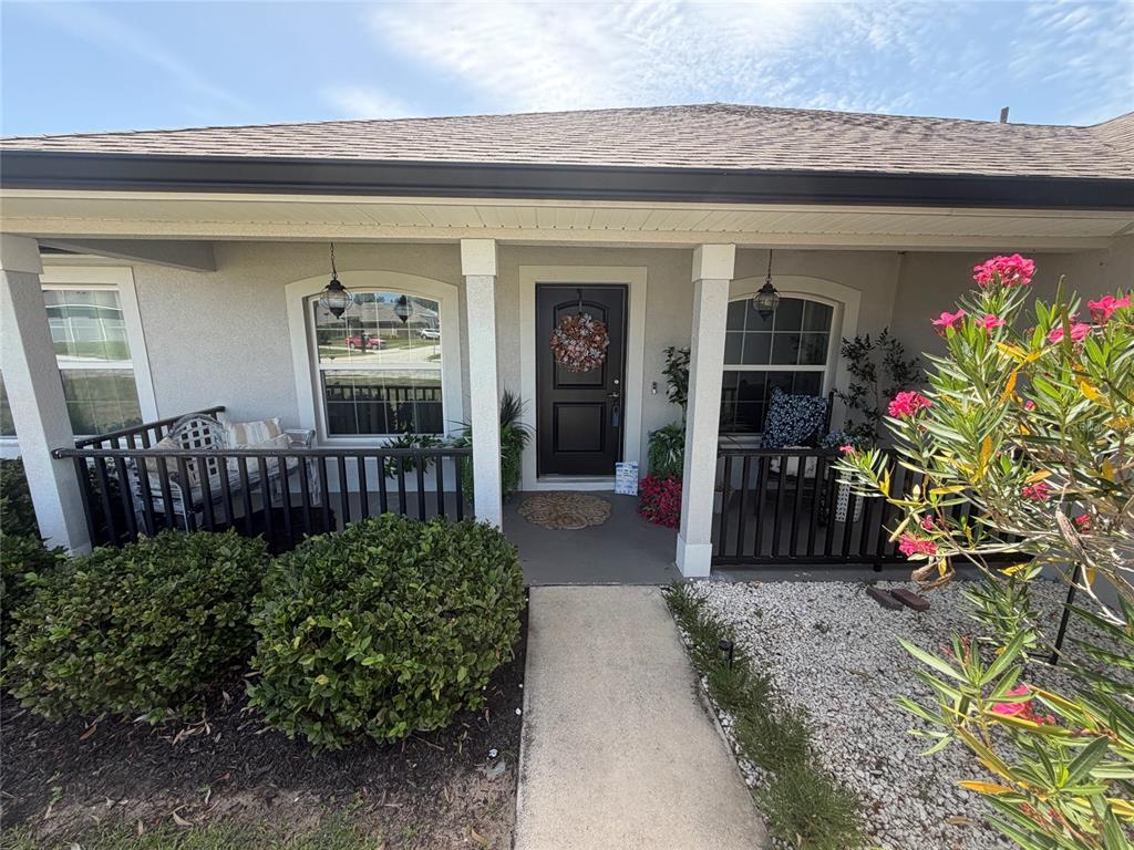 The exterior of a house features a covered front porch with black railings and columns — 1514 HAMLIN STREET, WINTER HAVEN, FL