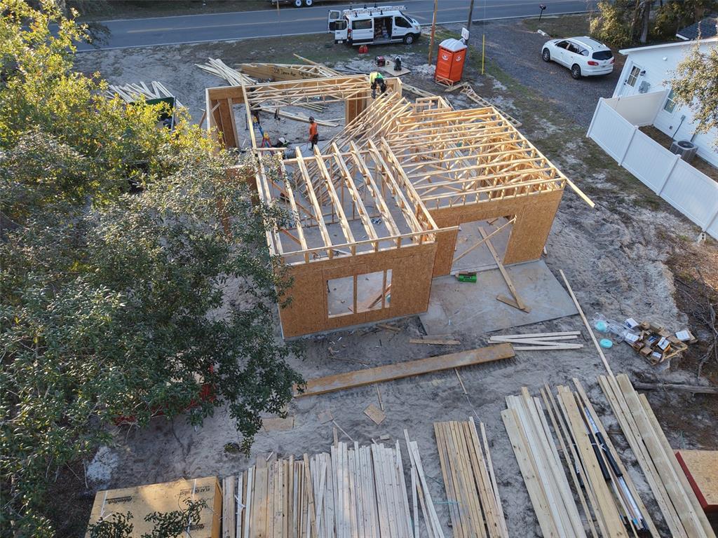 An aerial view shows a house under construction with exposed wooden framing and roof trusses — 228 DAWN AVENUE, INTERLACHEN, FL