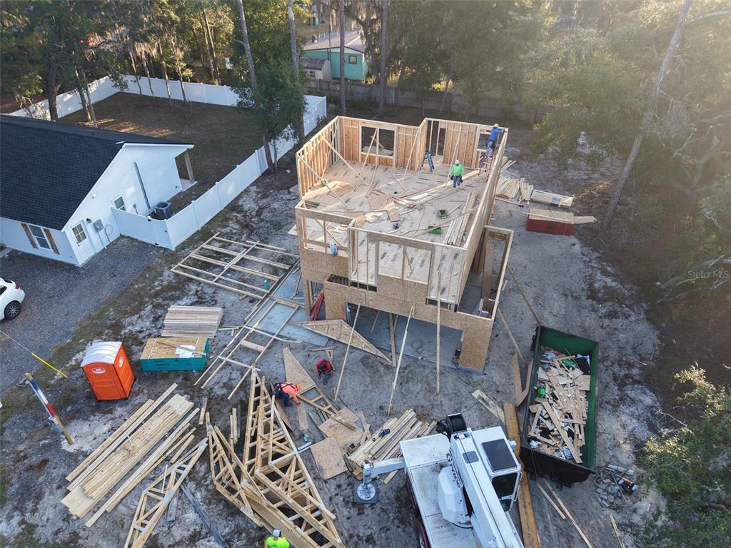 An aerial view shows a two-story house under construction with workers on the upper level — 228 DAWN AVENUE, INTERLACHEN, FL