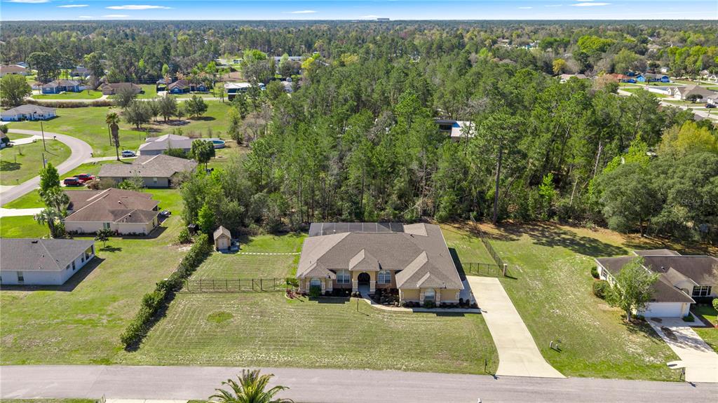 An aerial view shows a single-story house with a fenced yard and surrounding wooded area — 10411 SW 52ND COURT, OCALA, FL