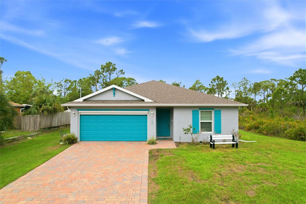 A single-story house with a teal garage door, matching shutters, and a brick paver driveway — 3215 SORREL STREET, PORT CHARLOTTE, FL