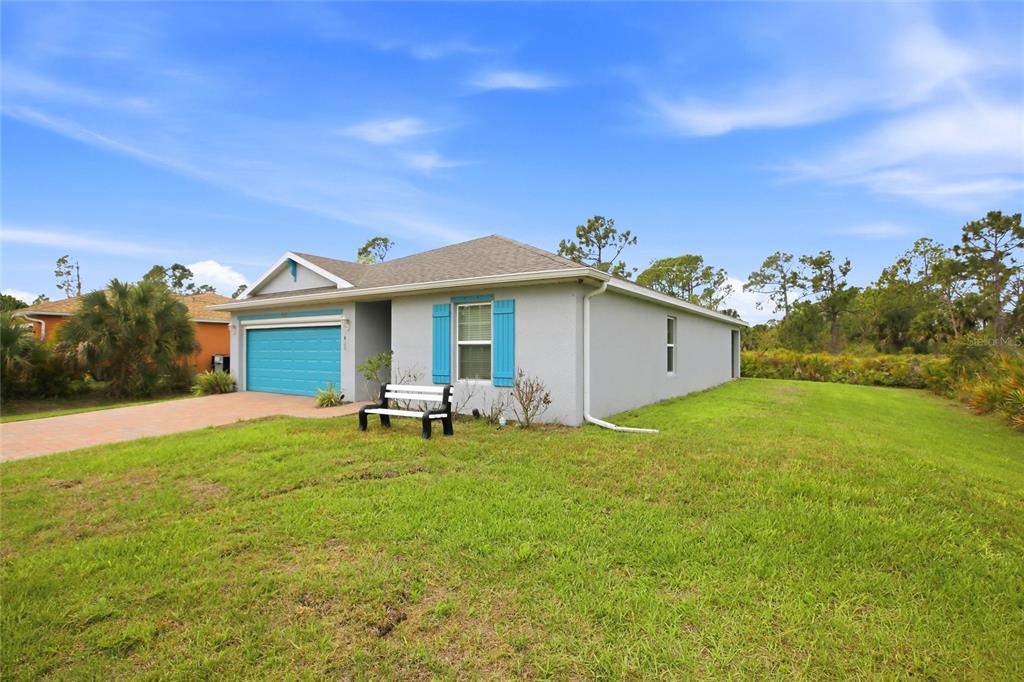 A single-story house with a blue garage door and blue shutters sits on a lawn — 3215 SORREL STREET, PORT CHARLOTTE, FL