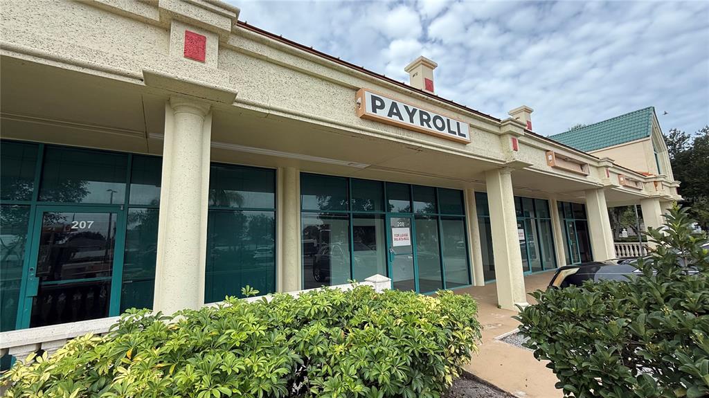 The exterior of a commercial building features a payroll sign and glass storefronts — 20101 PEACHLAND BOULEVARD, PORT CHARLOTTE, FL