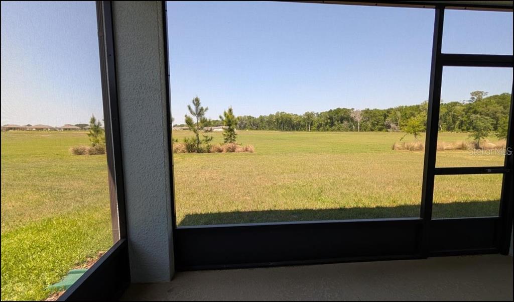 A single-story house with a two-car garage, light-colored siding, and a landscaped front yard — 8479 SW 52ND LANE ROAD, OCALA, FL